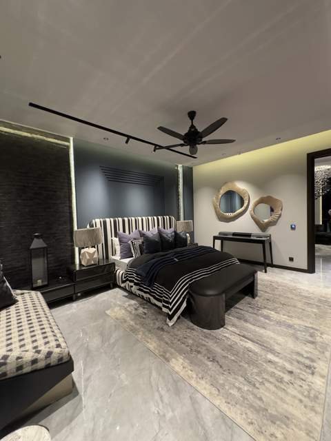 Primary bedroom with striped upholstered headboard