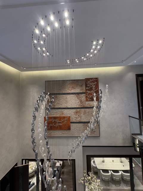 Feature wall with calligraphy art and sculptural chandelier